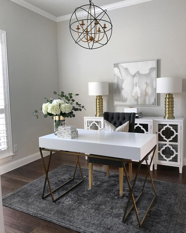 a white table with two chairs and a chandelier