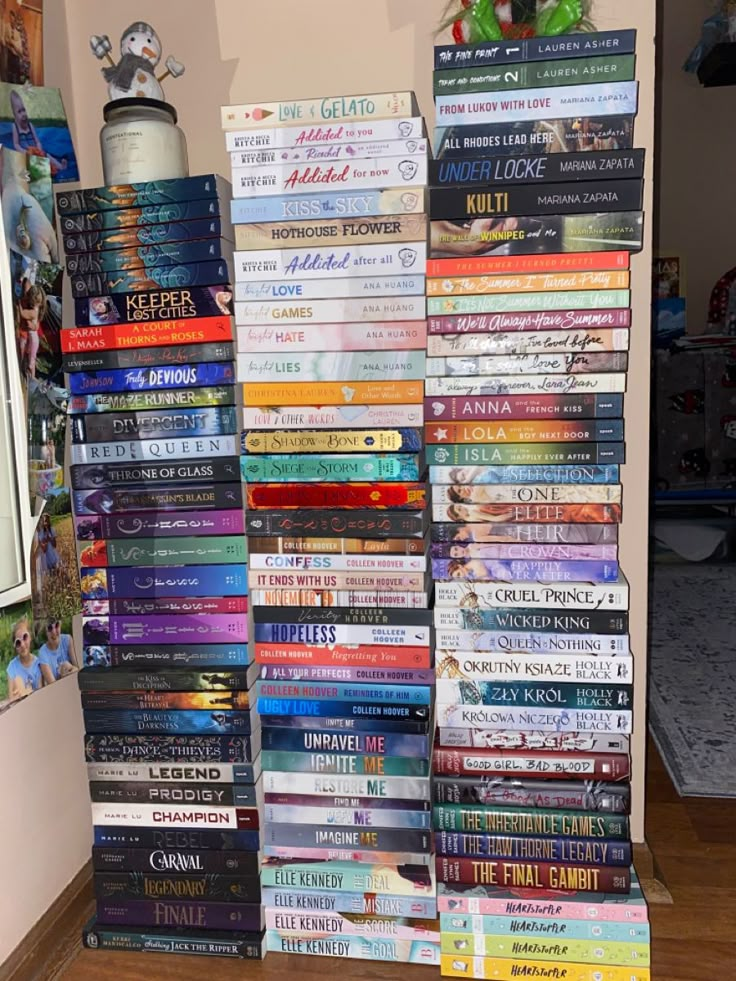 a stack of books sitting on top of a hard wood floor next to a wall