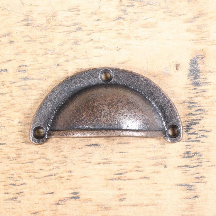 an old metal handle on a wooden surface