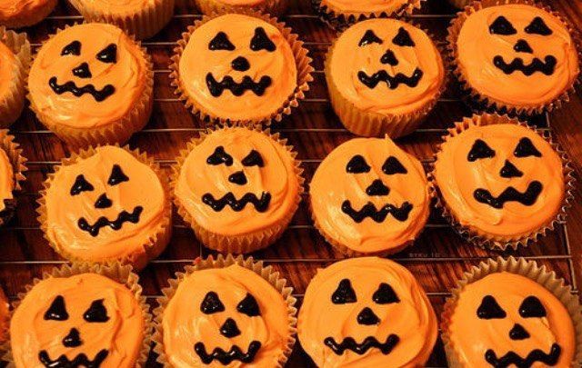 cupcakes with orange frosting decorated like jack - o'- lanterns