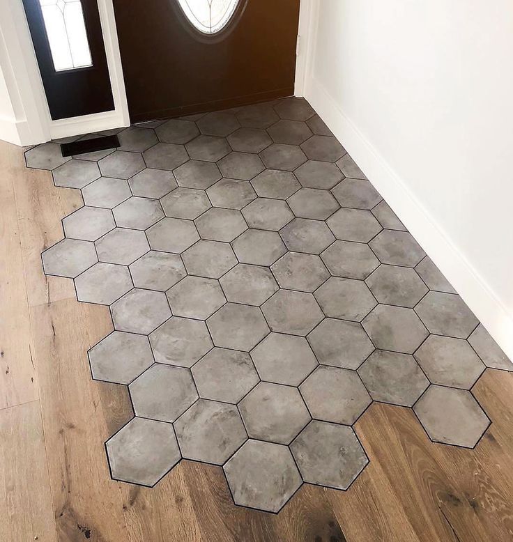 the floor is made up of hexagonal tiles and wooden floors, with a door in the background