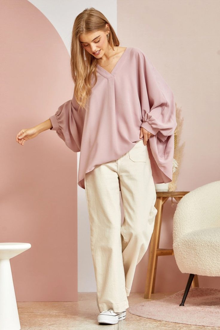 This blouse is out to prove that comfy and chic can coexist in perfect harmony. Its flowy, dolman cut gives you room to breathe while still maintaining a flattering drape. 3/4 sleeves keep it seasonal, transitioning effortlessly from summer to fall. A plunging V-neckline shows just enough skin to be subtly seductive, but the blush pink hue is as sweet and charming as an English rose garden. In short, this top lets you make a stylish statement without having to sacrifice one ounce of comfort. It’ Relaxed Fit V-neck Tunic For Fall, V-neck Rayon Blouse For Loungewear, Rayon V-neck Blouse For Loungewear, Effortless V-neck Blouse For Fall, Effortless Fall V-neck Blouse, Flowy Blouse For Spring Loungewear, Oversized Versatile V-neck Blouse, Versatile Oversized V-neck Blouse, Oversized Effortless Blouse For Spring