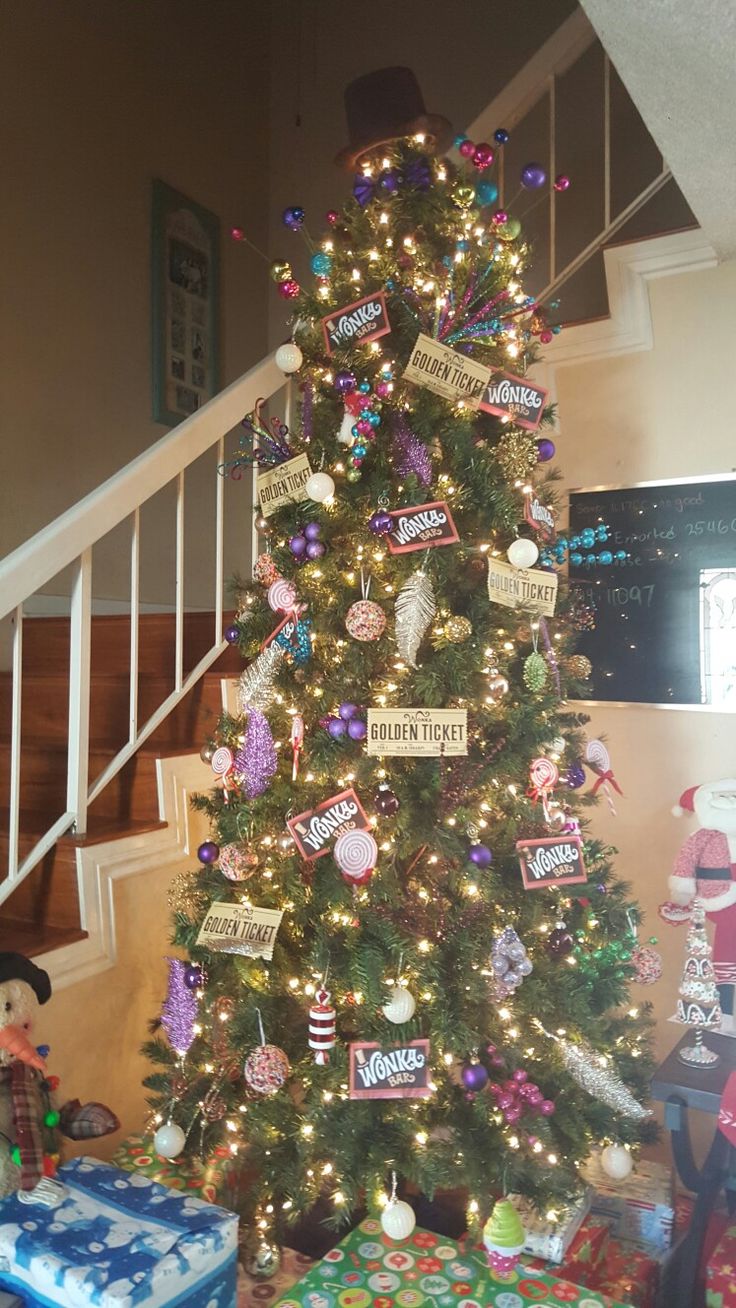 a decorated christmas tree in the corner of a room with presents on the floor and stairs