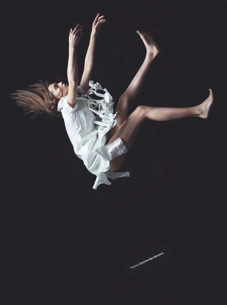 a woman flying through the air while wearing a white dress