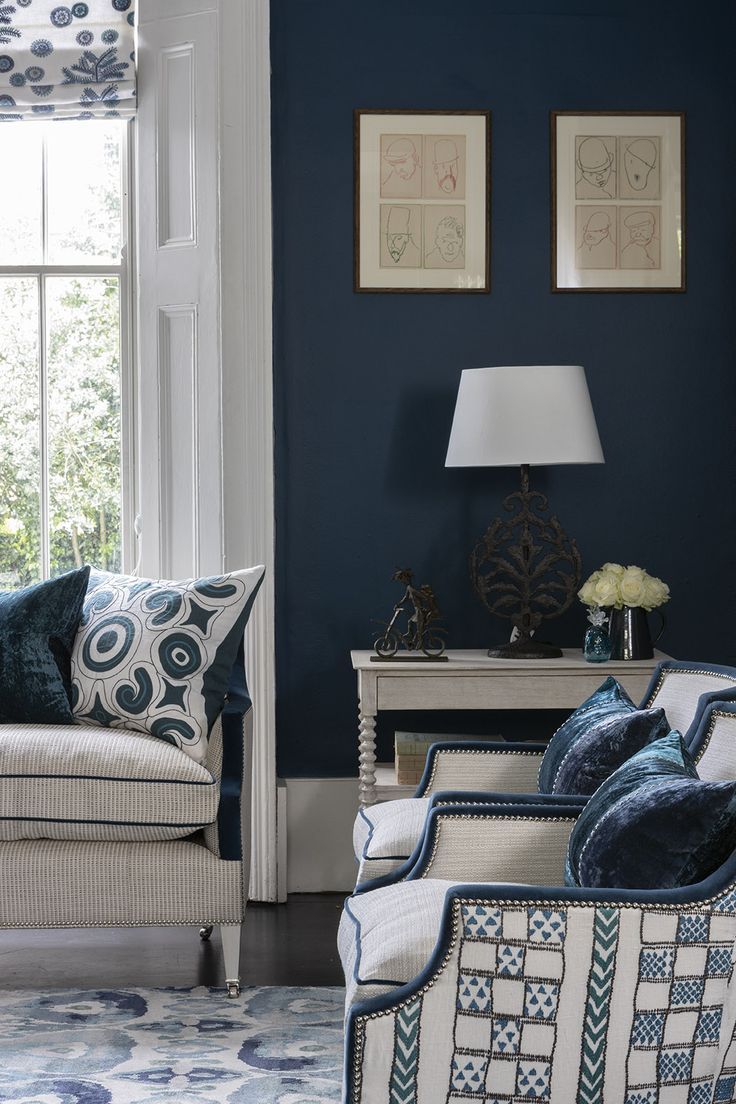 a living room with blue walls and white furniture