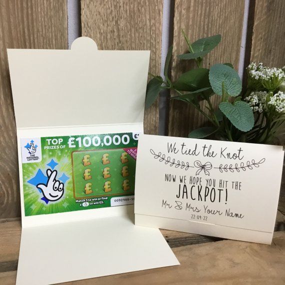 there is a card and envelope on the table next to each other, with a plant in the background