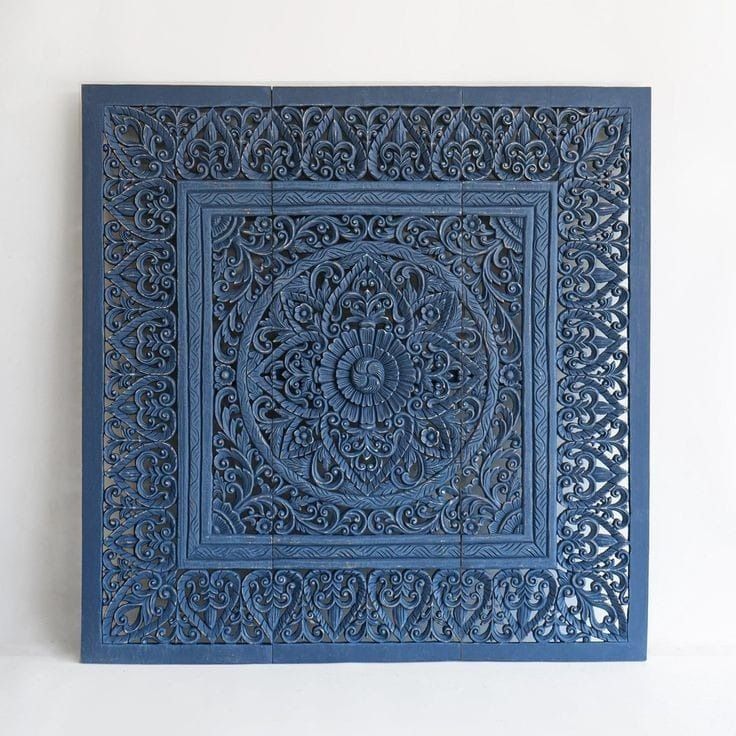 an intricately carved blue tile is displayed on the wall in front of a white wall