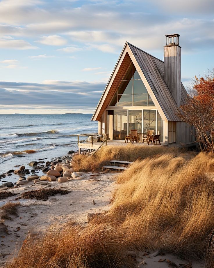 a small house on the beach with an ocean in the background