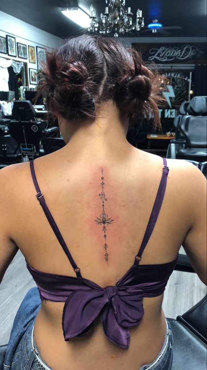 a woman with a cross tattoo on her back