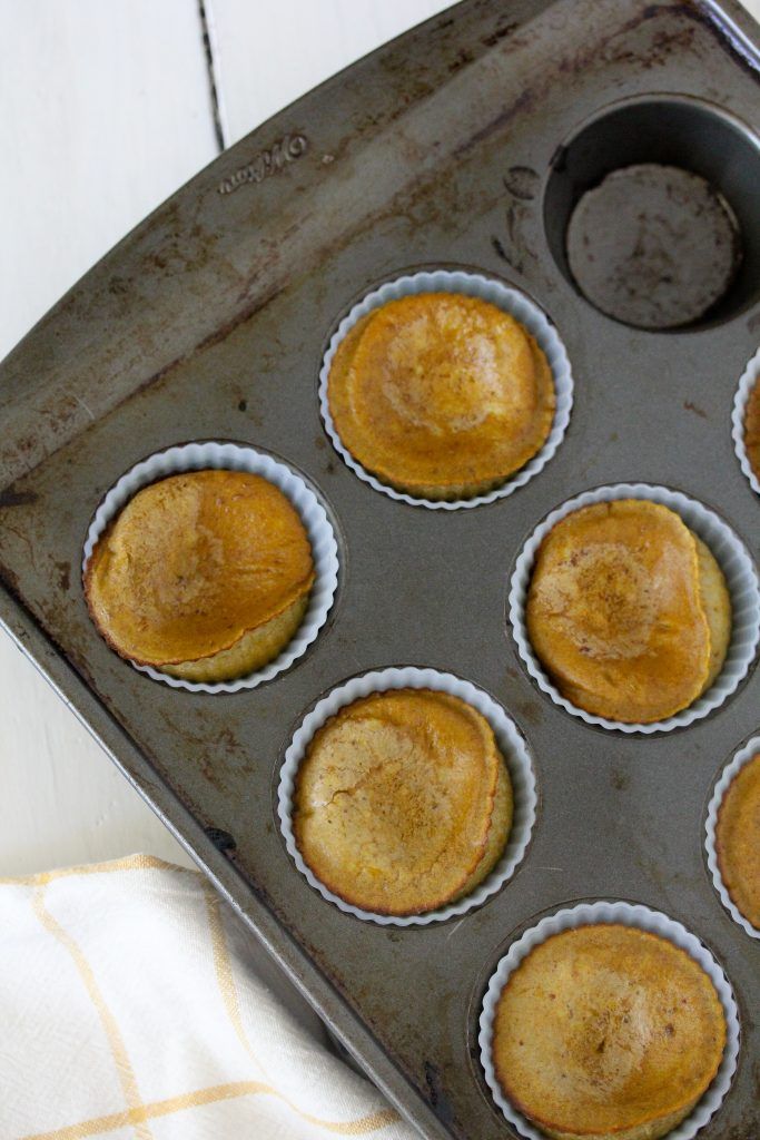 a muffin tin filled with cupcakes on top of a table