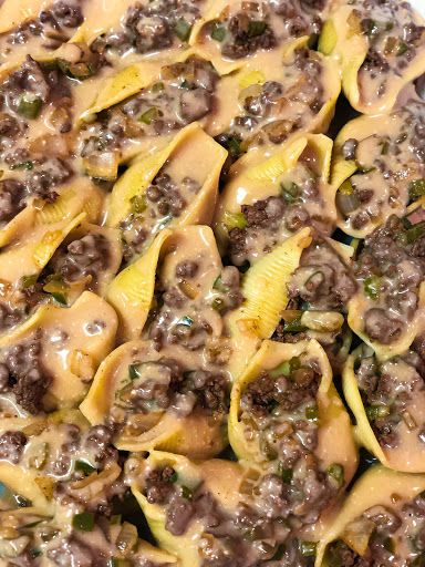 closeup of pasta shells covered in cheese and ground beef