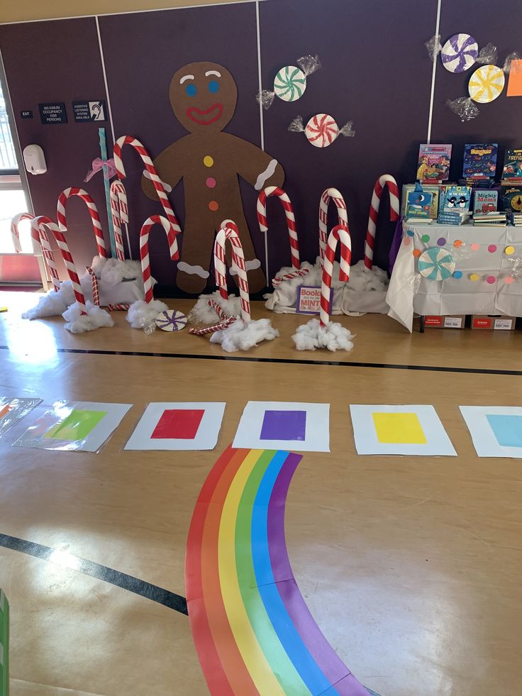 some candy canes are on the floor in front of a wall decorated with gingerbread man