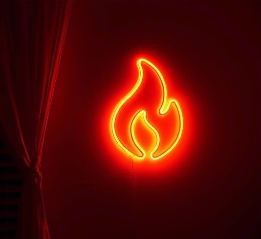 a red neon sign with a flame on it's side in a dark room