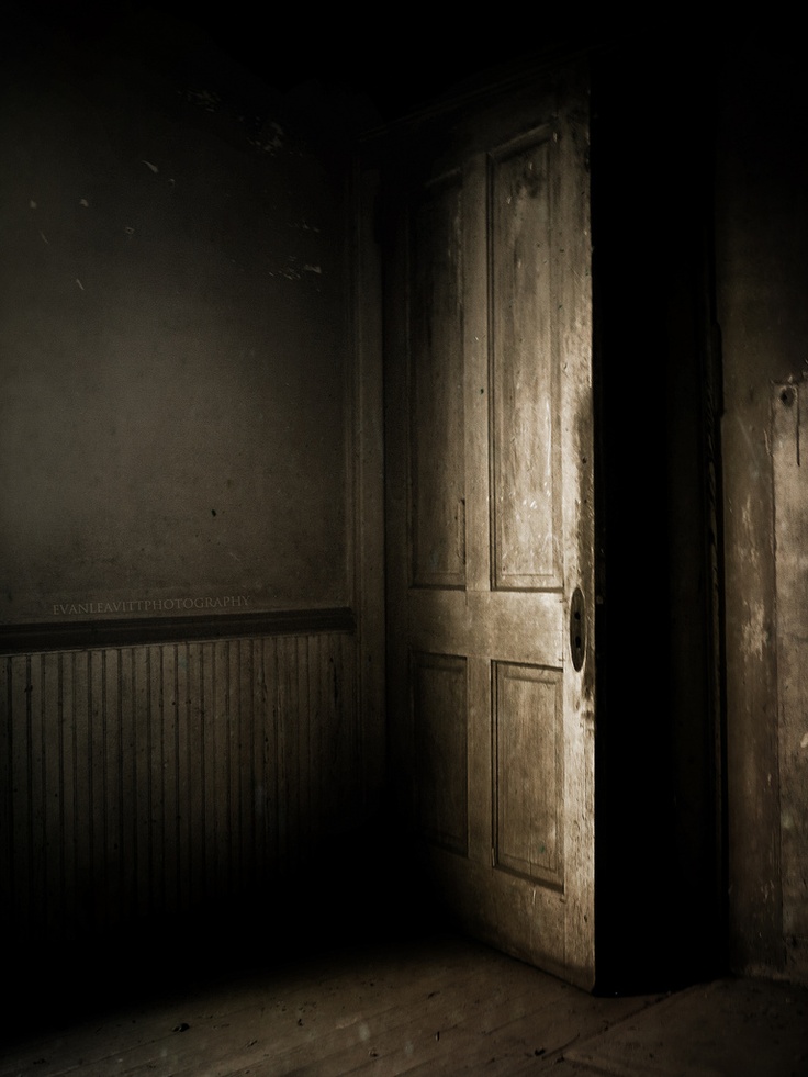 an open door in a dark room with no light on it and only the floor