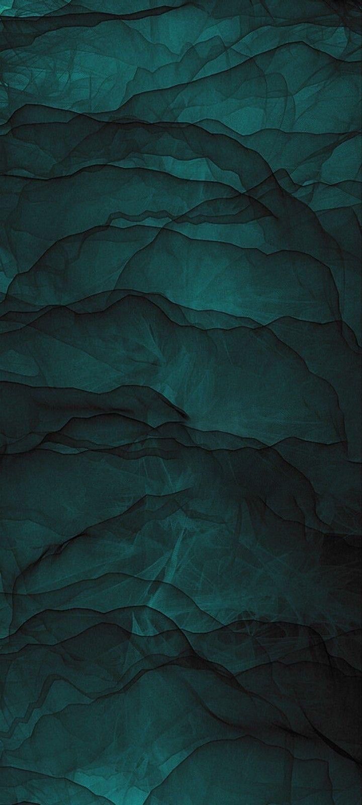 an abstract photo of dark green paper with wavy lines on the bottom, and light at the top