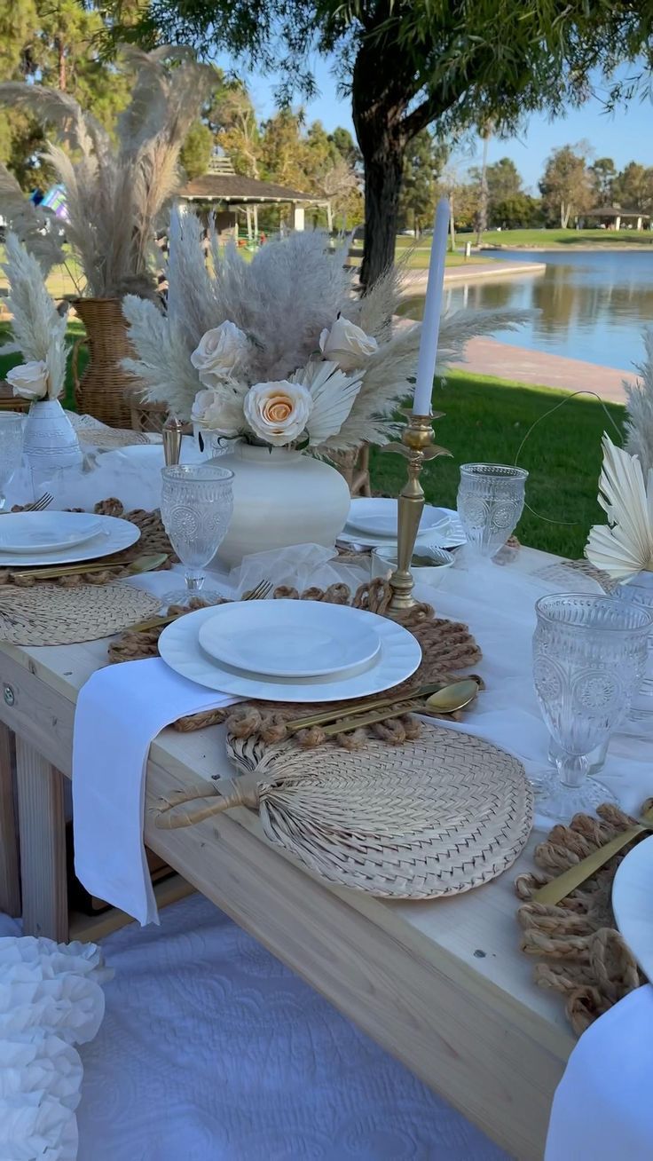 the table is set with white dishes and place settings