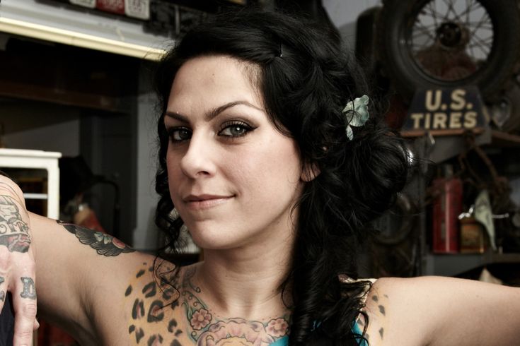 a woman with tattoos on her chest and arm