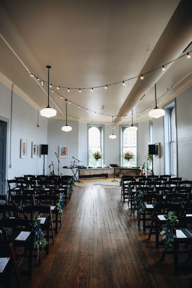 an empty church with rows of chairs and string lights