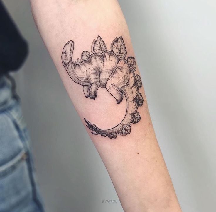 an elephant sitting on the moon with leaves around it's neck and tail tattoo