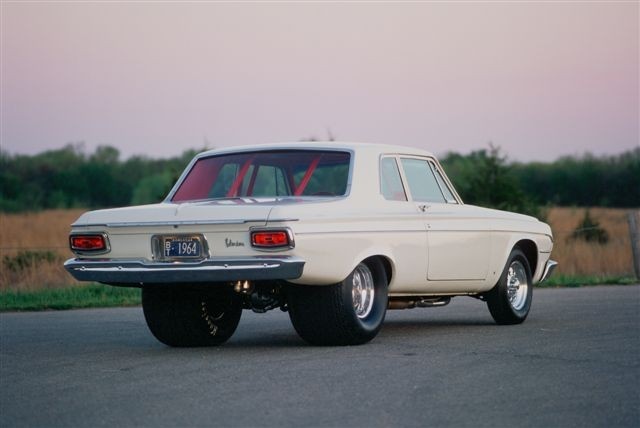 an old white car is parked on the street