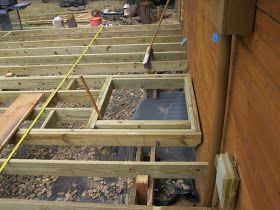 an unfinished house being built with wood framing and tools on the ground next to it