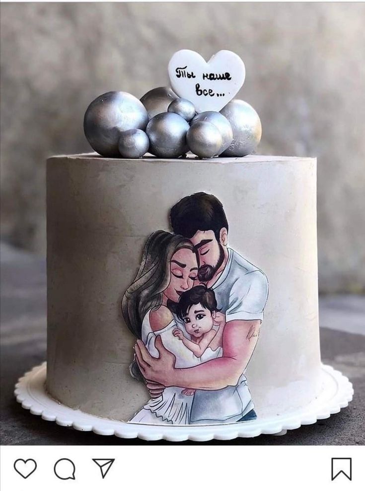 a cake decorated with an image of a man and woman holding a baby on top of it