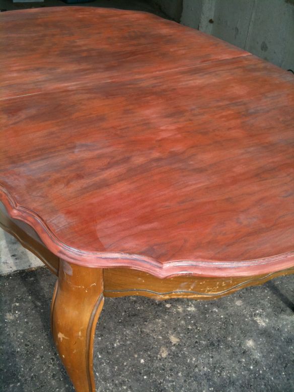 an old wooden table with red paint on it