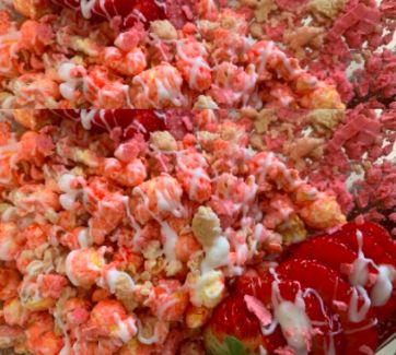 the dessert is covered in pink and white sprinkles, strawberries, and marshmallows