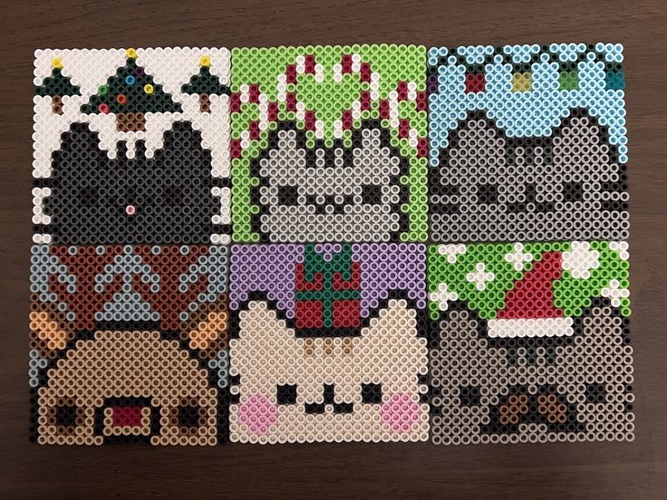 cross stitch christmas cards on a table with cats and snowflakes in the background