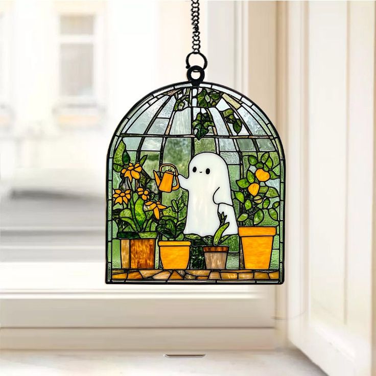 a stained glass window with a ghost hanging from it's side and potted plants on the other side