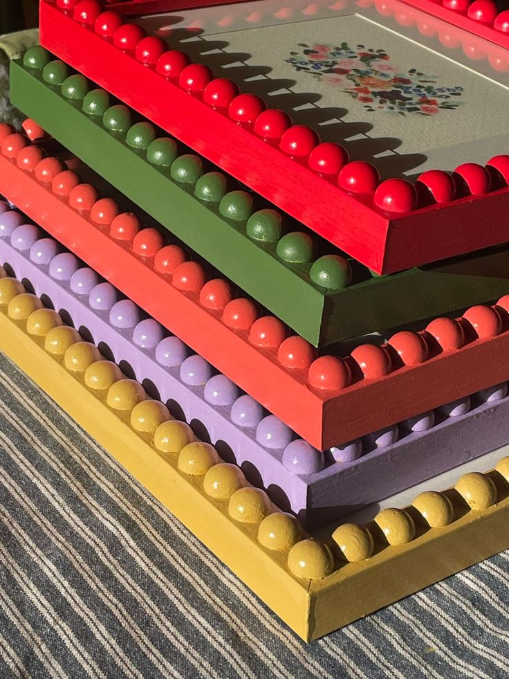 a stack of different colored beads on top of each other in front of a wall