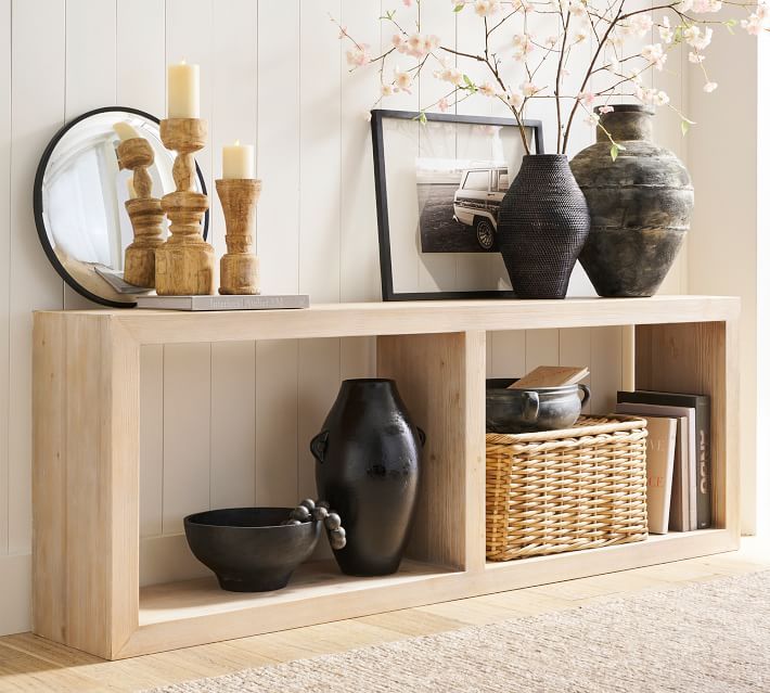 a shelf with vases and other items on top of it in a living room