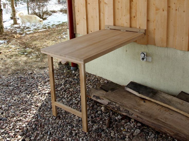 a wooden bench sitting next to a building