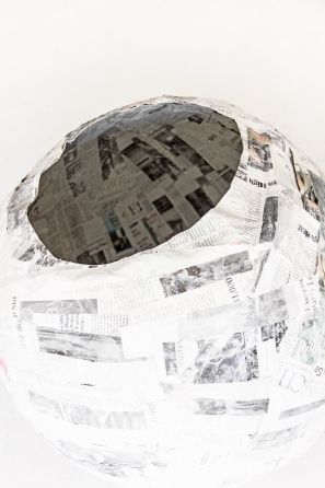 a paper mache is sitting on the floor with newspaper all over it's surface