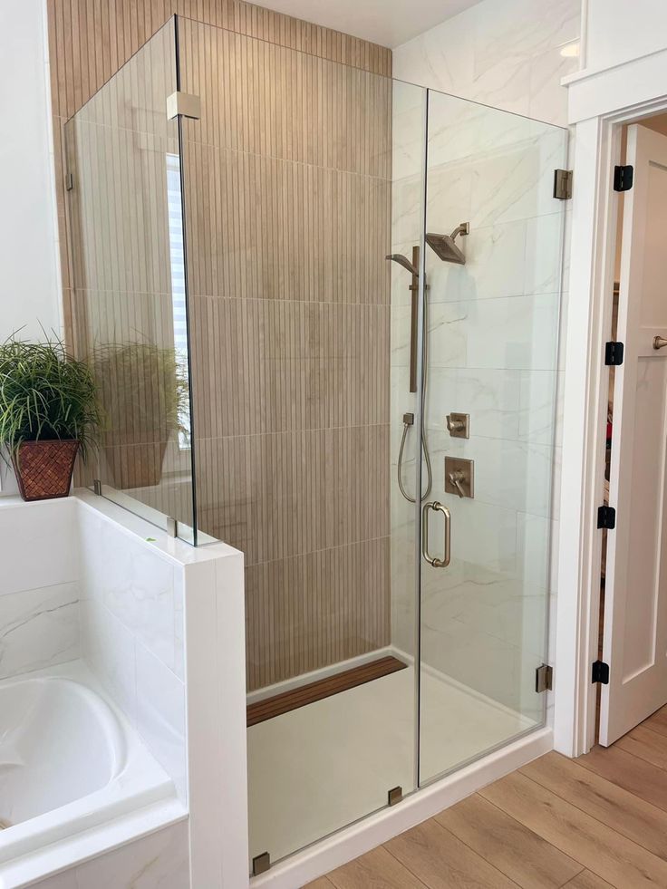 a bathroom with a walk in shower next to a bathtub