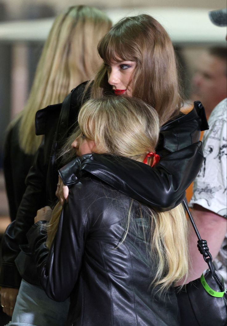 two women hug each other as they walk through an airport