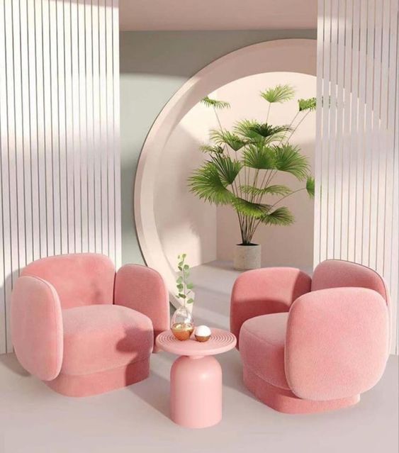 a living room filled with pink furniture and a round mirror