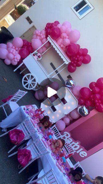 pink and white balloons are on display at a party