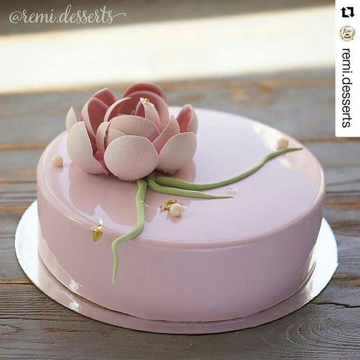 there is a pink cake with flowers on it