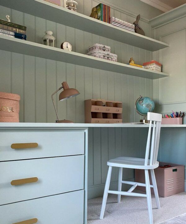 a white chair sitting in front of a desk with drawers and shelves on it's sides