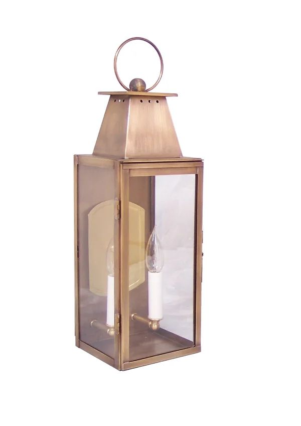 an old - fashioned brass lantern with two white candles on the front and one in the back