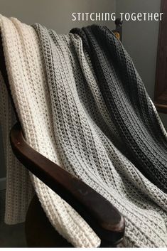 a white and black blanket sitting on top of a wooden chair