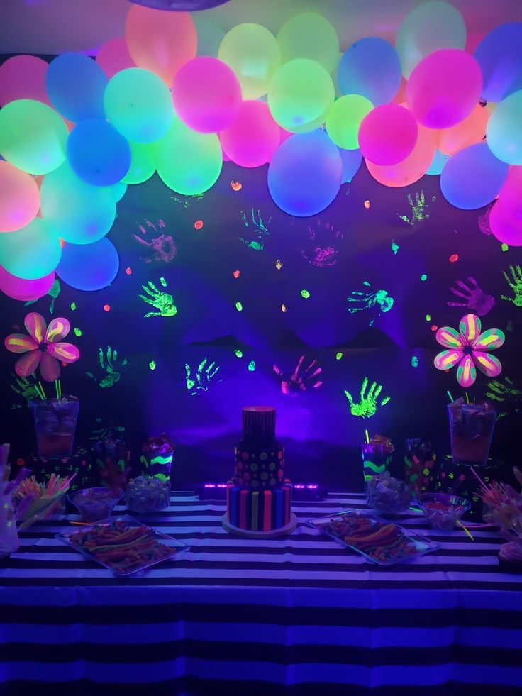 a table topped with lots of balloons and flowers