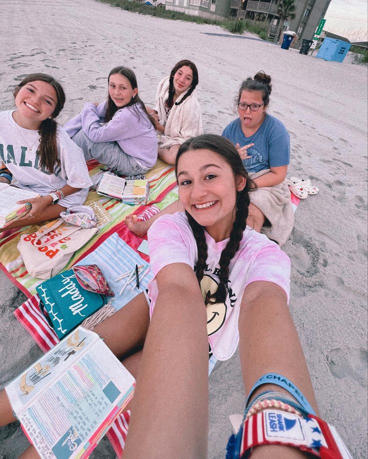 a group of women sitting on top of a beach next to each other