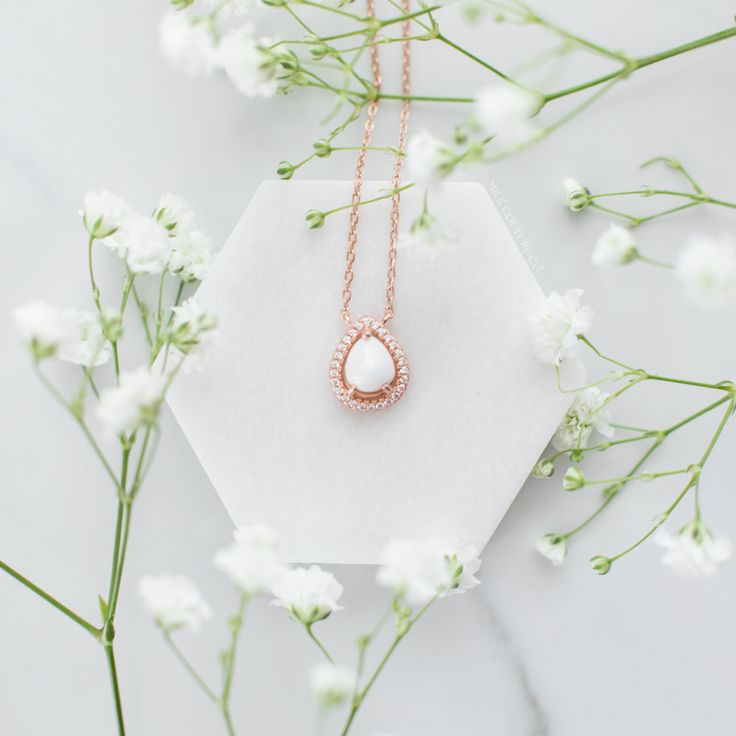 The meaning of "Halo Au Lait" is "Halo with Milk" in French, reflecting the essence of the necklace. The drop-shaped stone is expertly crafted to resemble a drop of milk, capturing the sacrifice of motherhood. Its unique shape also adds deep symbolism to the necklace, reminding us of the life-giving nature of breastmilk. Elegant Drop Keepsake Necklaces, Elegant Drop-shaped Keepsake Necklaces, Elegant Drop Necklaces For Keepsakes, Elegant Keepsake Drop Necklace, Minimalist White Keepsake Necklace, White Birthstone Necklace For Keepsake, Delicate White Oval Pendant Necklace, Pear-shaped Pearl Pendant Necklace As Gift, Rose Gold Teardrop Necklace With Pearl Pendant