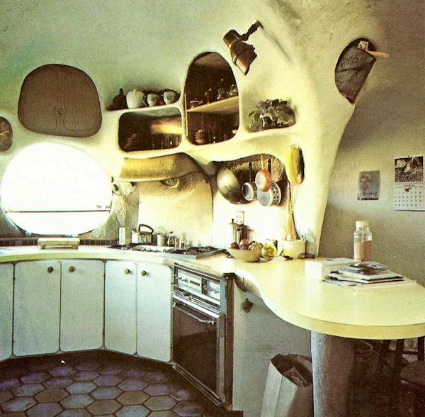 a kitchen with an oval shaped counter top and shelves on the wall next to it