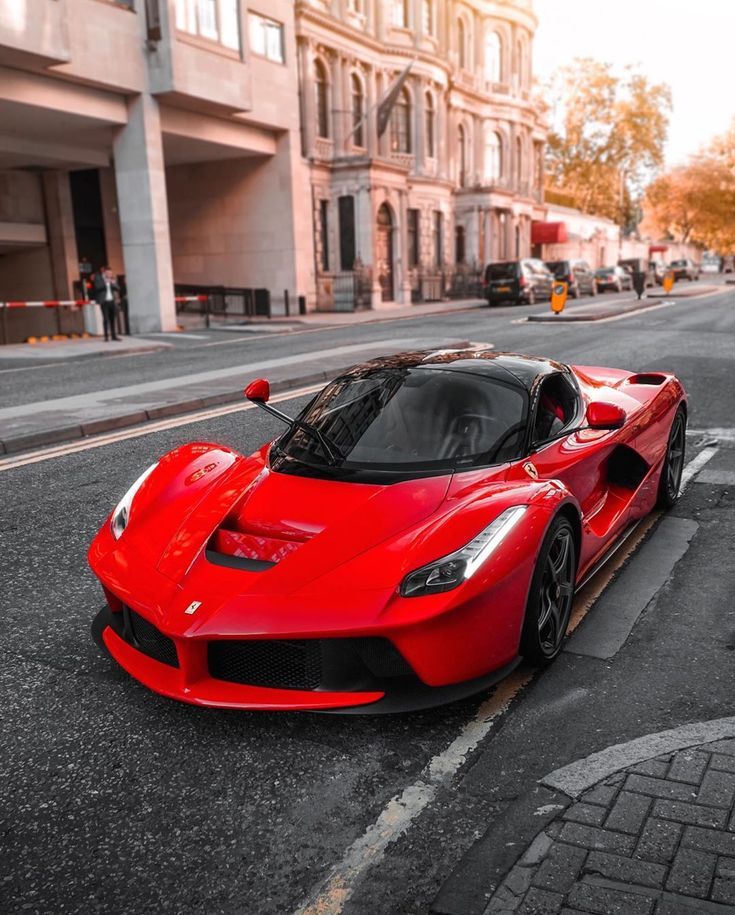 a red sports car is parked on the street