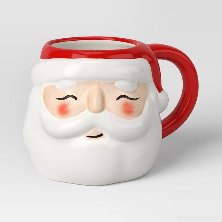 a red and white mug with a santa face on it