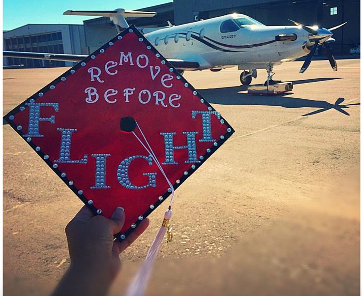 someone is holding up a red graduation cap with the words remove before flight on it