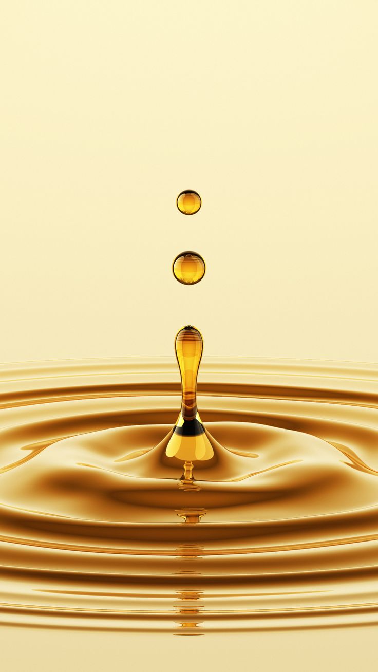 an orange liquid splashing into the water on top of a yellow surface with ripples